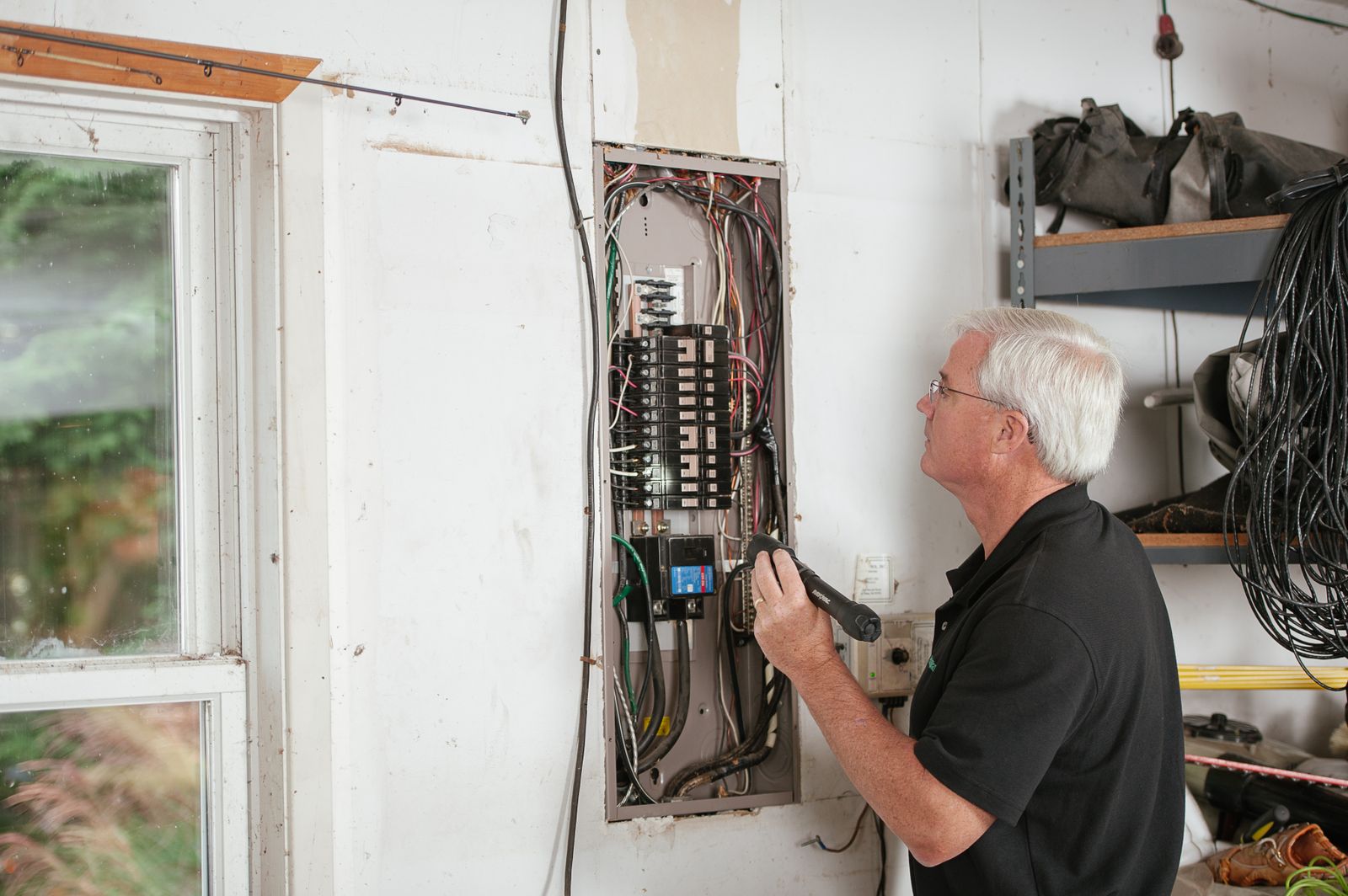 An electrician inspecting a home's electrical panel