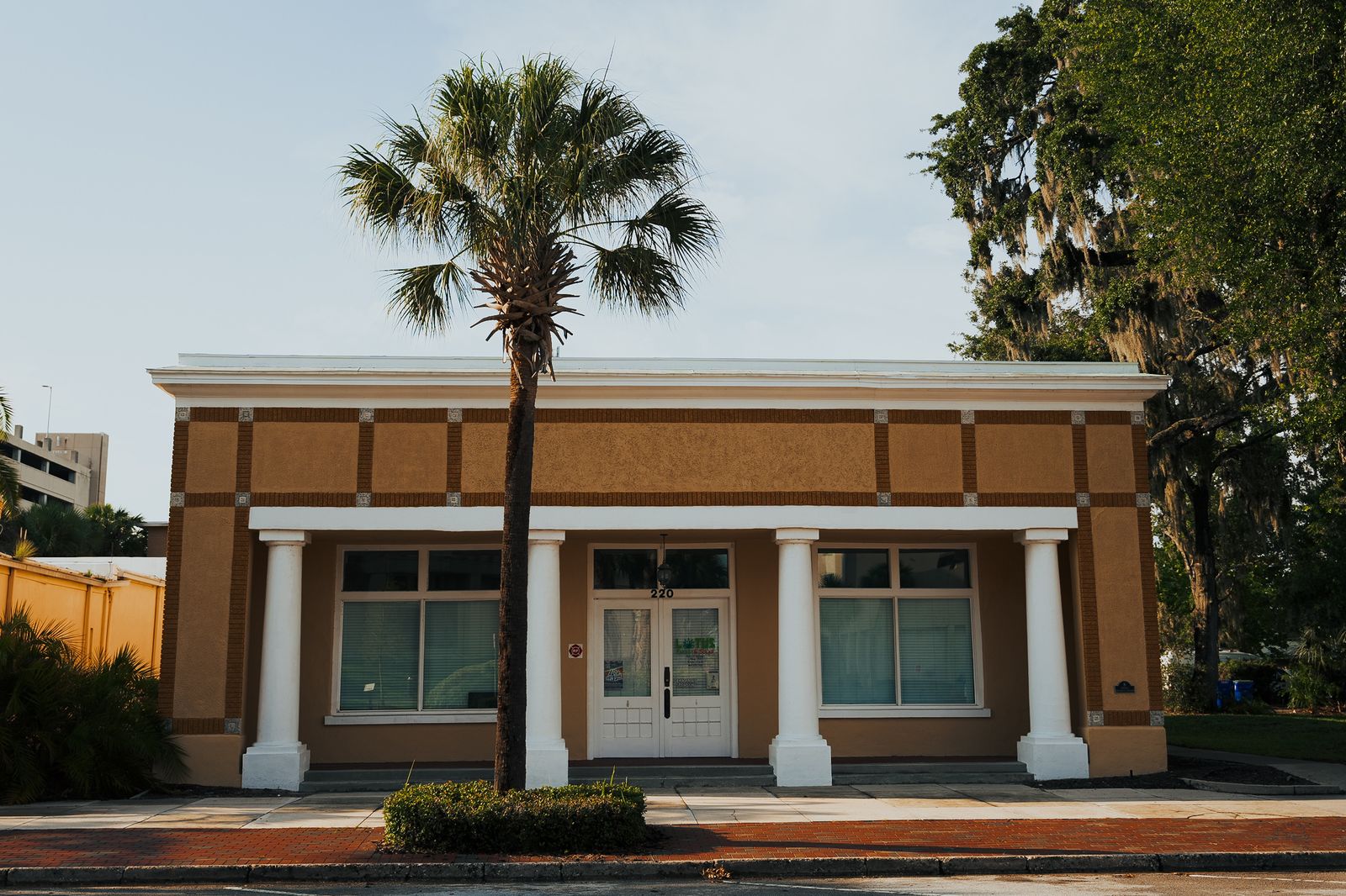 A single-story commercial building with white columns