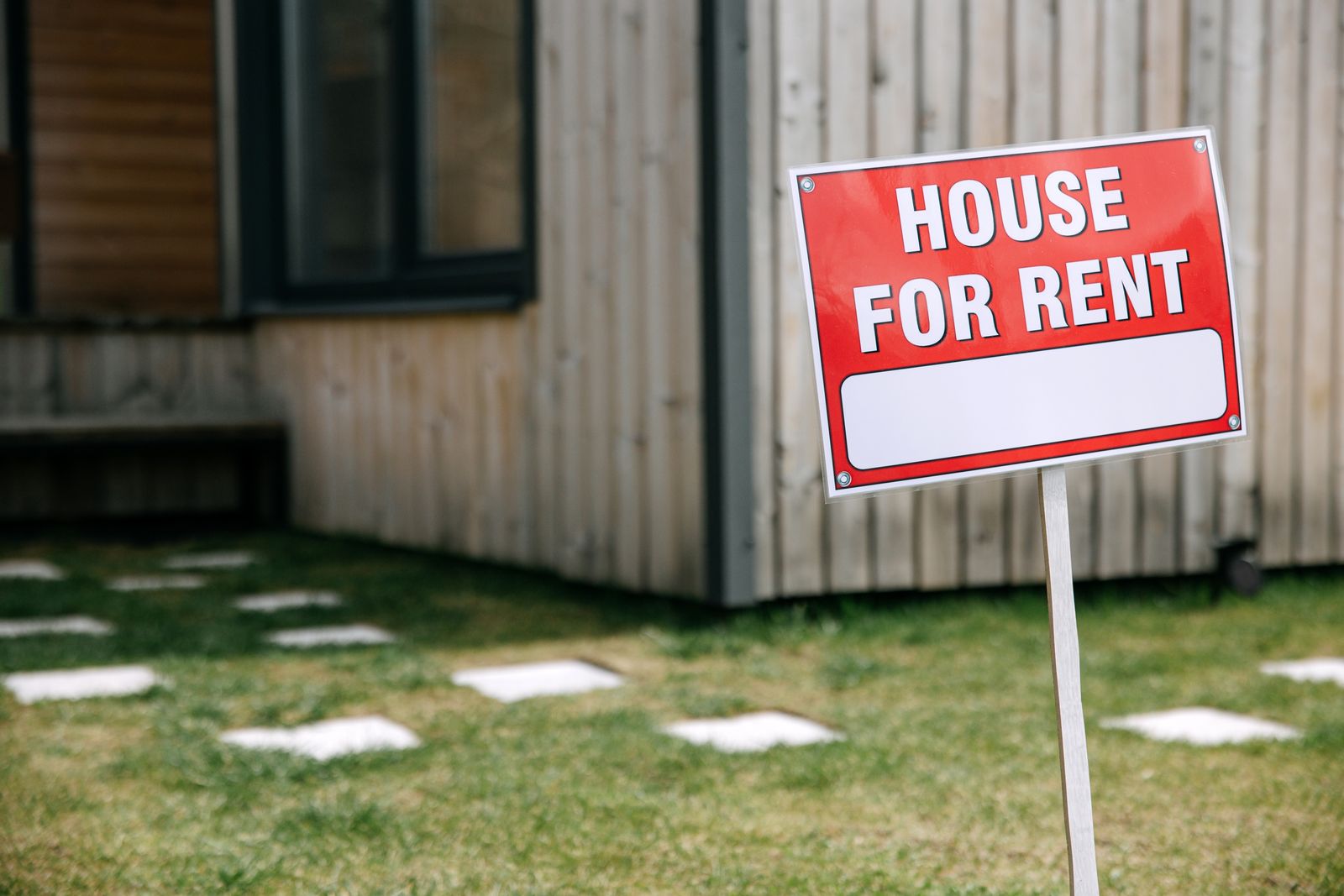 A rental house with a For Rent sign in the yard