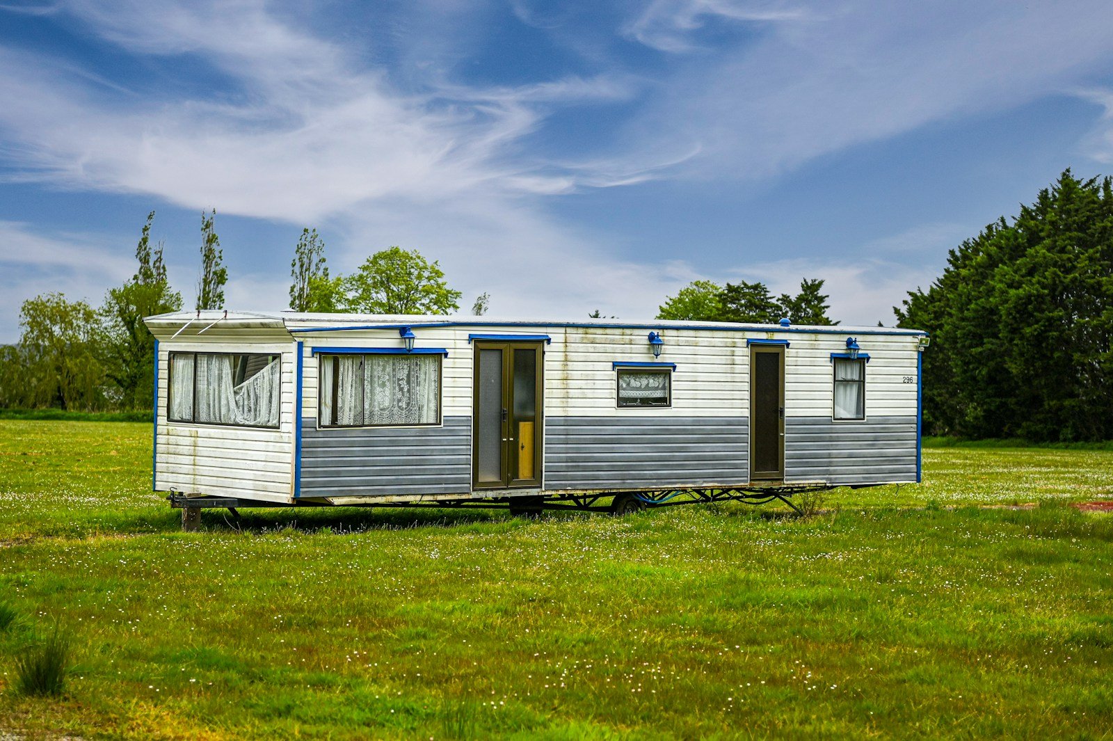 A mobile home sitting in a grassy field