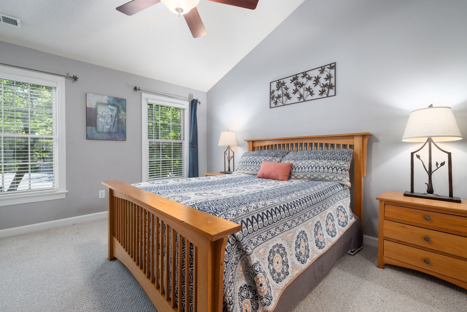A made bed in a sunny bedroom